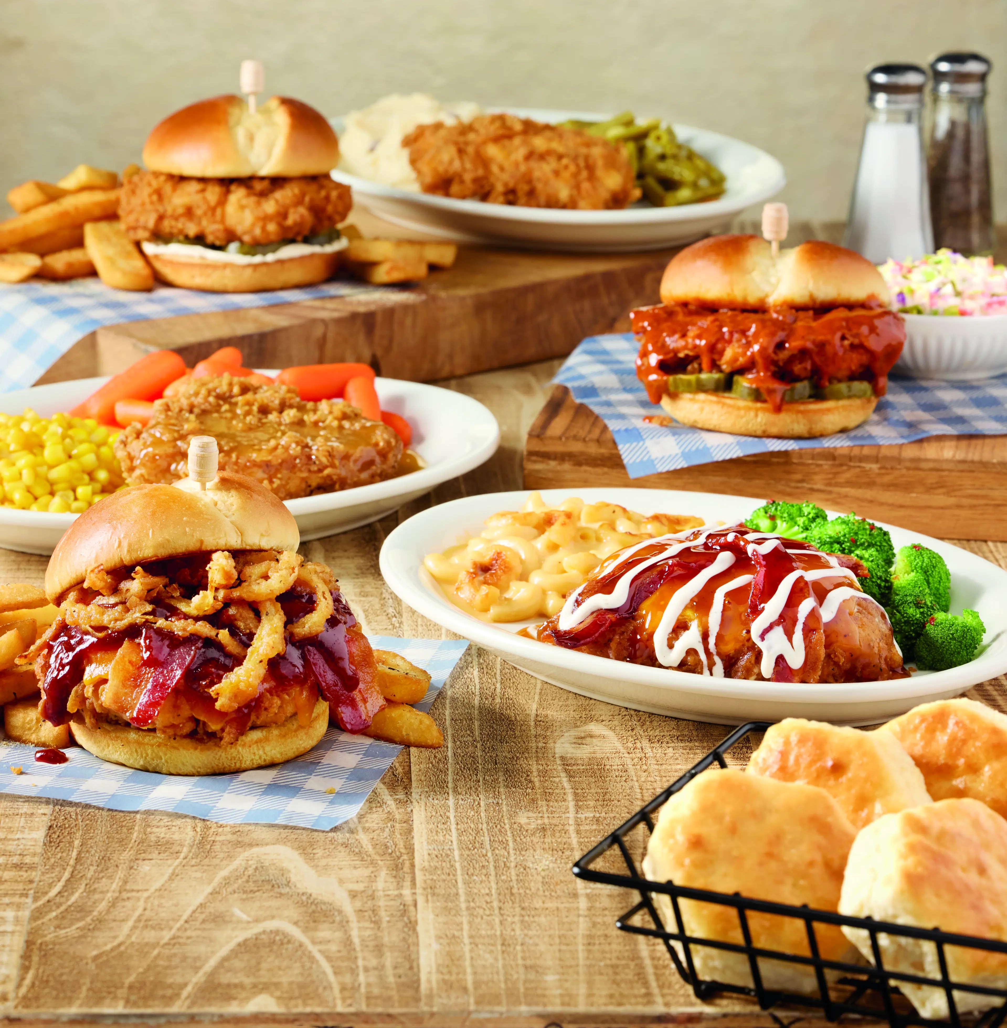 Assortment of Cracker Barrel meals, including fried chicken sandwiches, homestyle entrées, macaroni and cheese, vegetables, and sides.